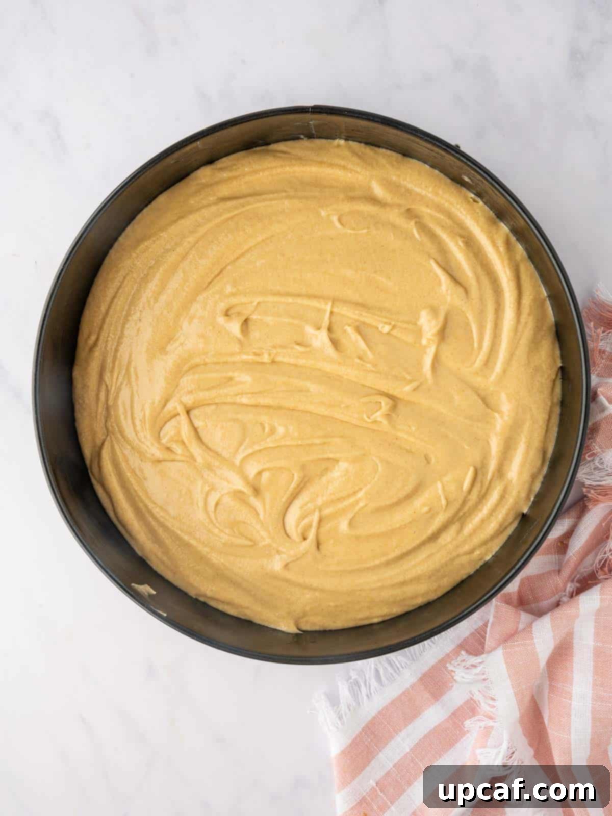 Caramelized Pear Crown Cake 13 Cake batter is evenly spread over the pear layer in the pan.