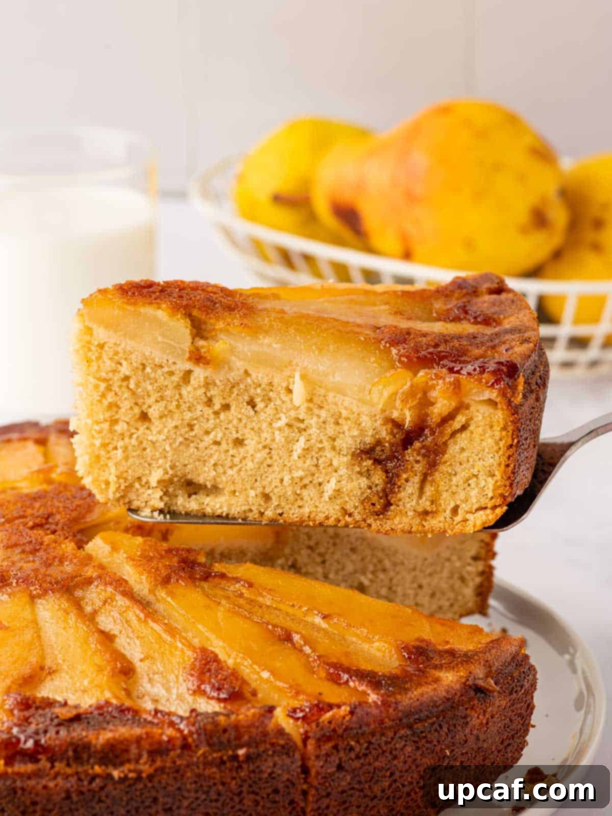 Caramelized Pear Crown Cake 17 A beautiful slice of pear cake is lifted above the rest of the cake.