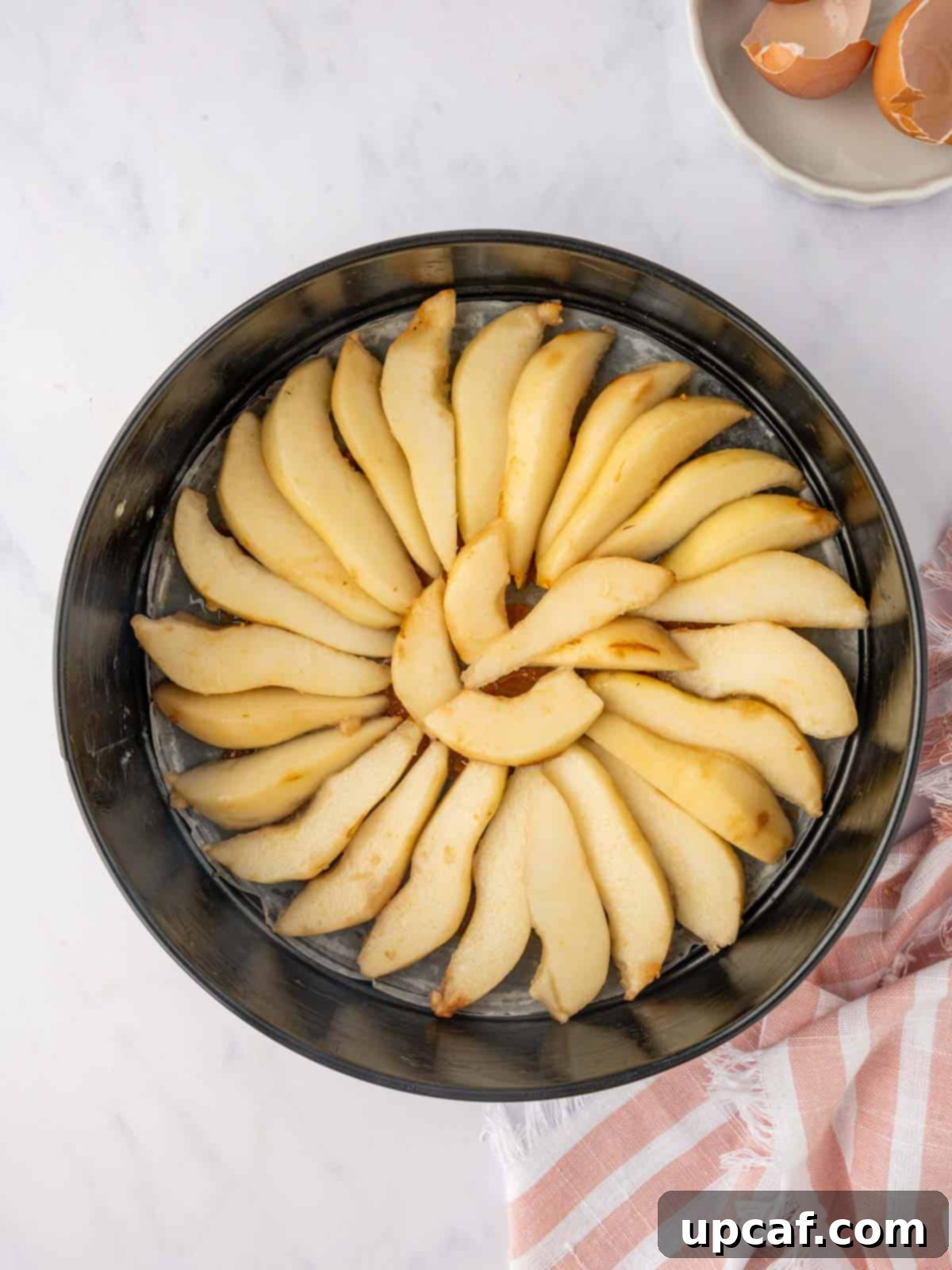 Caramelized Pear Crown Cake 7 Pear slices are artfully arranged in a cake pan over caramel.