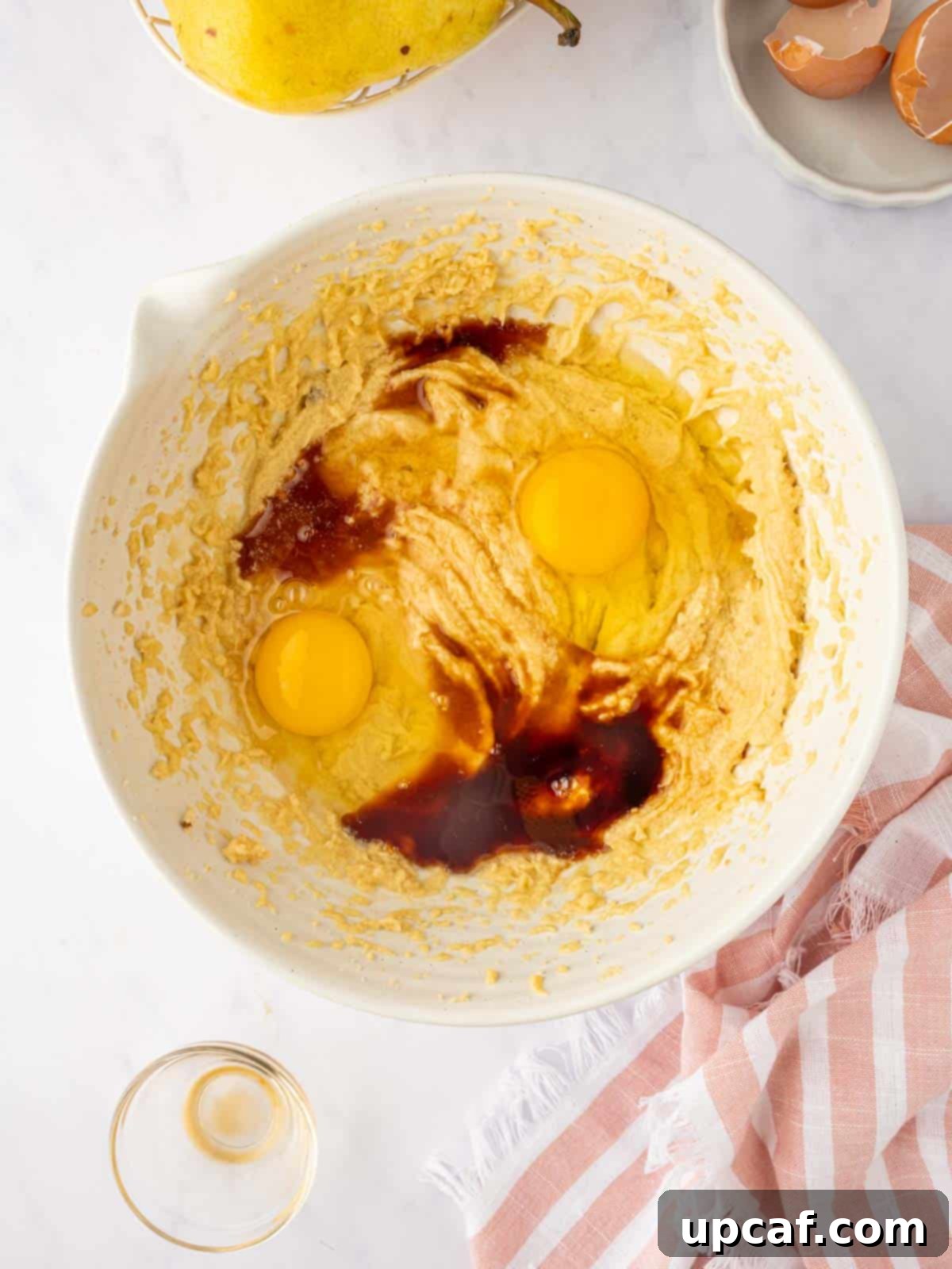 Caramelized Pear Crown Cake 10 The cake batter is prepared in a bowl, showing a light, fluffy texture.