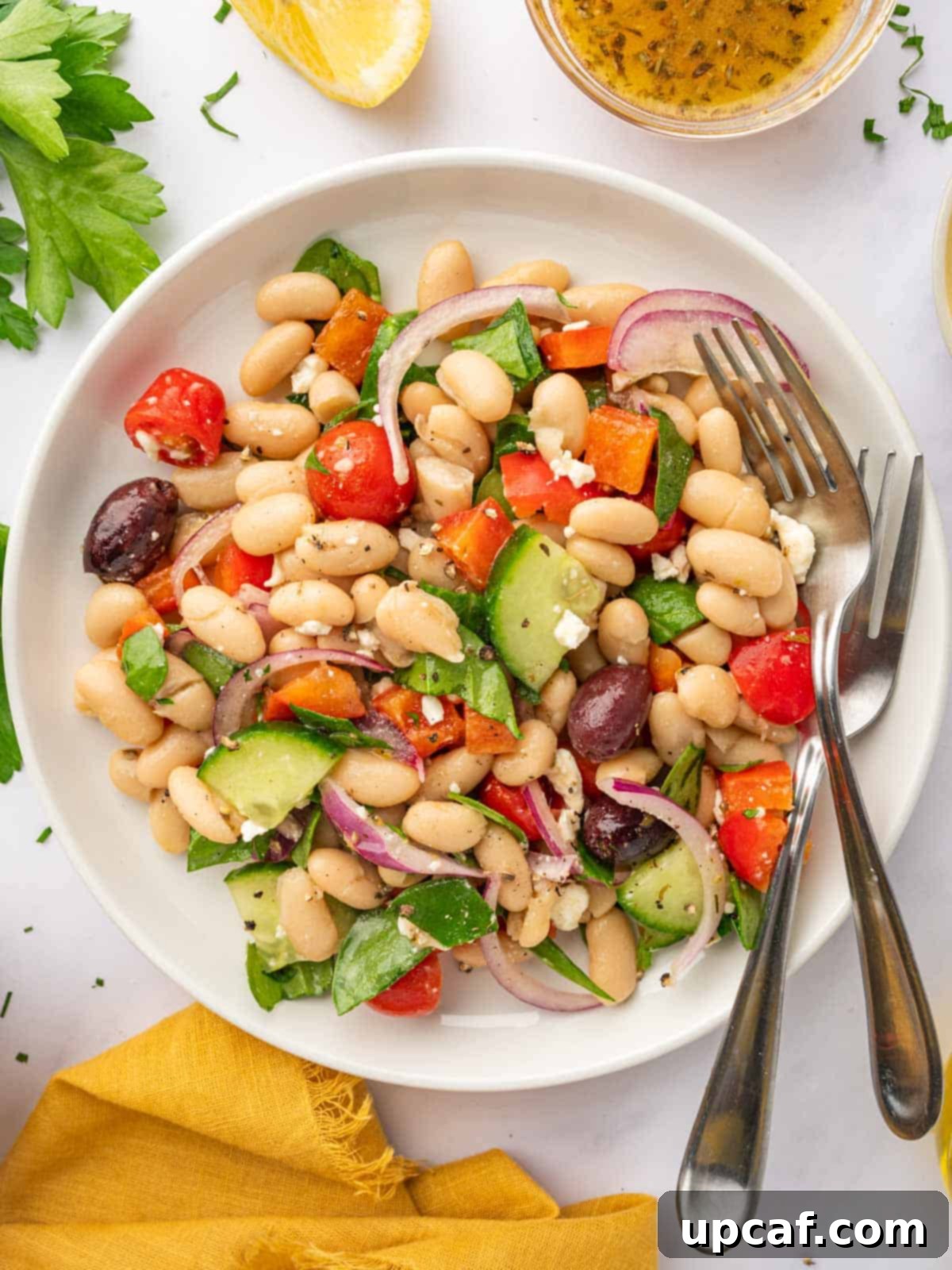 A bowl of Greek Bean Salad with two forks resting on the side.