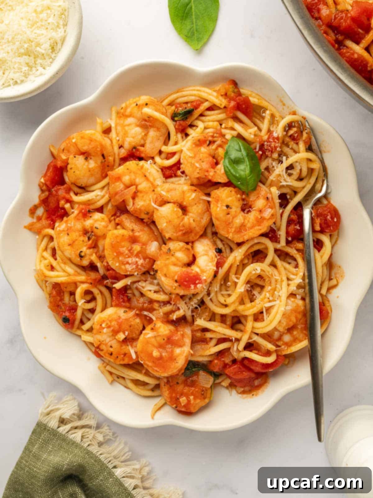 A bowl of pasta topped with sauteed shrimp.