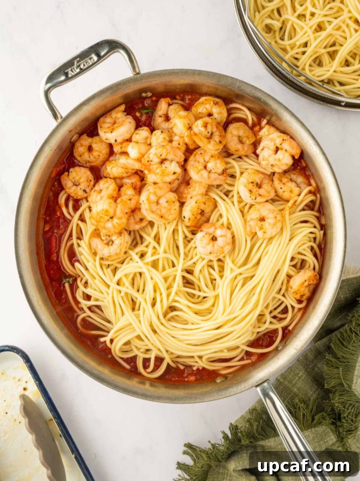 Combine the cooked pasta and shrimp with the sauce in the skillet.
