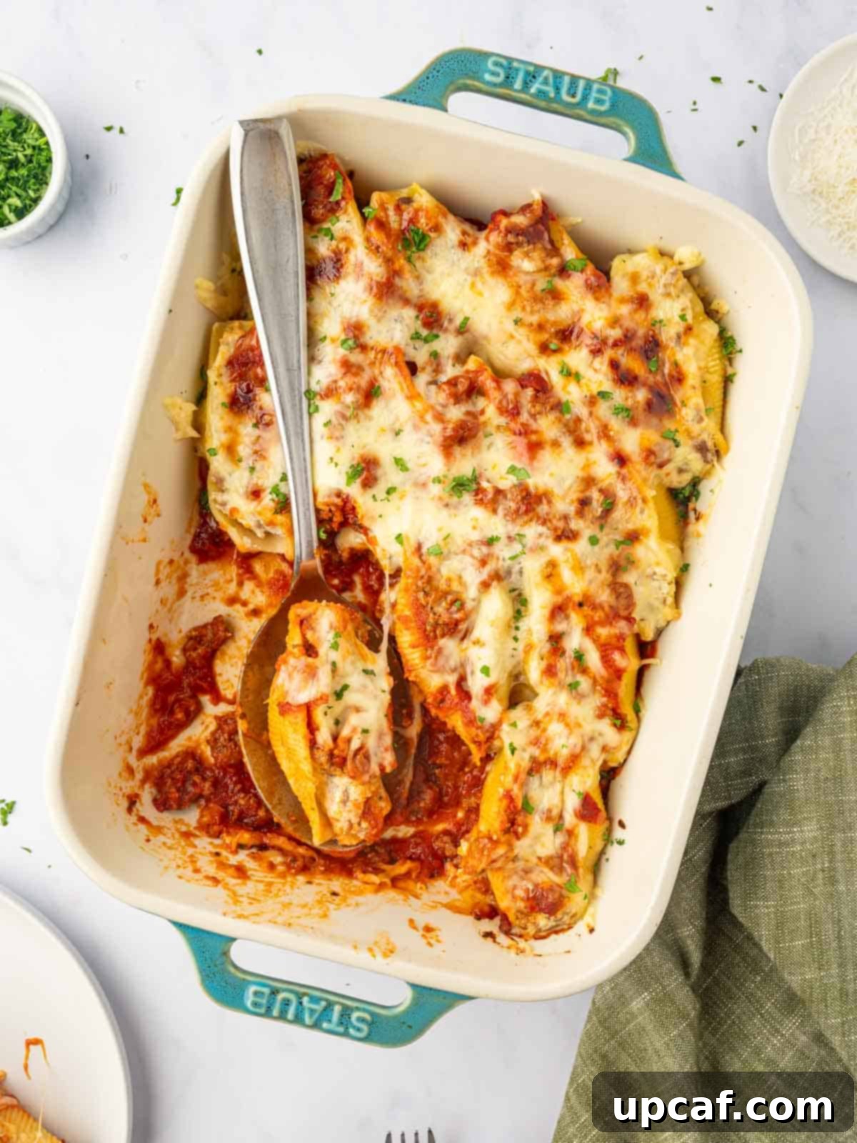 Hearty Beef and Ricotta Stuffed Shells 12 A large casserole dish filled with beautifully baked beef stuffed shells, topped with melted golden-brown cheese.