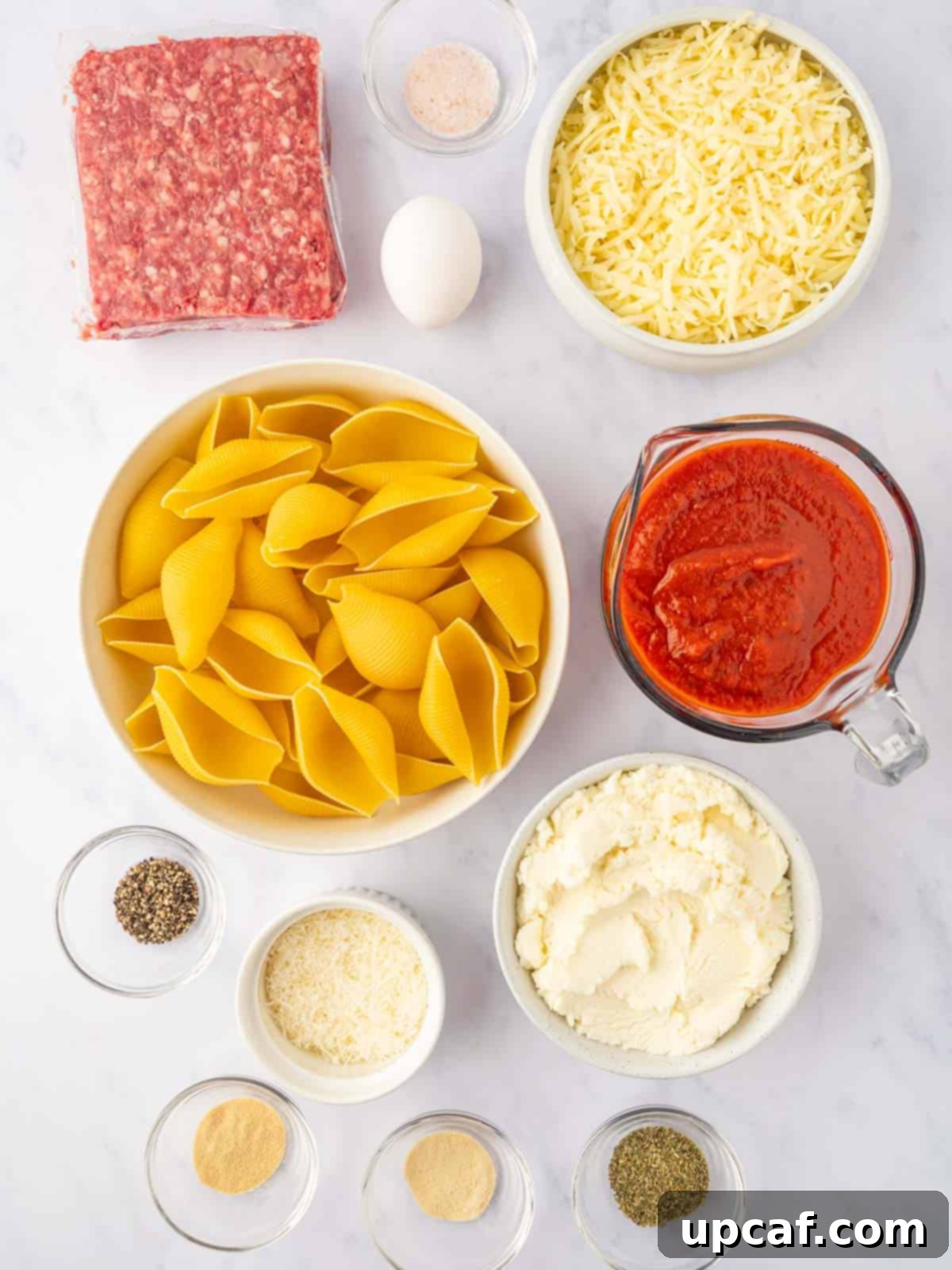Hearty Beef and Ricotta Stuffed Shells 3 A vibrant selection of fresh ingredients laid out, including jumbo pasta shells, ground beef, cheeses, marinara, and various seasonings, ready for making beef stuffed shells.