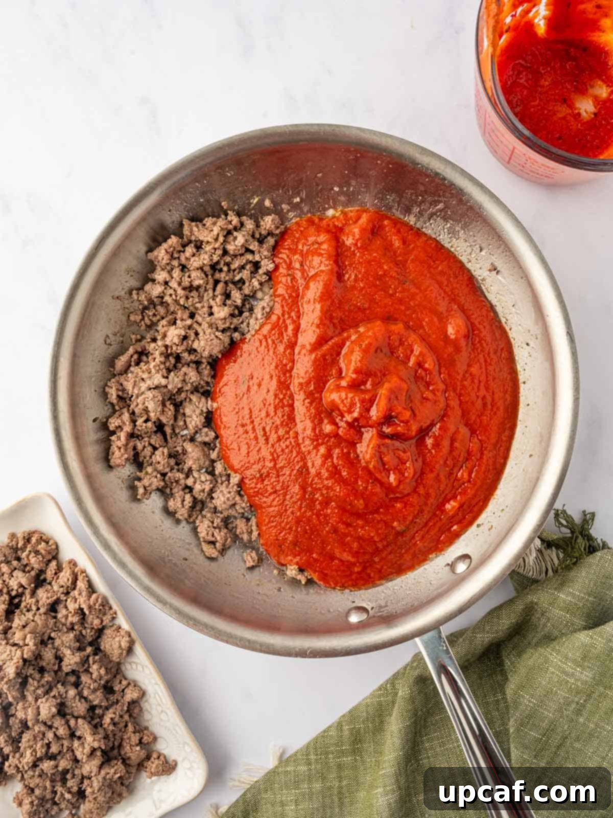 Hearty Beef and Ricotta Stuffed Shells 6 The browned ground beef expertly combined with marinara sauce in a skillet, creating a rich and aromatic meat sauce.