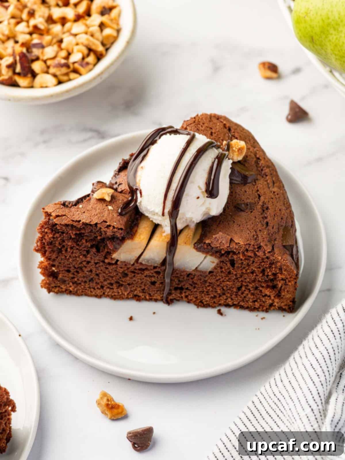 Chocolate Pear Bliss 11 A delectable slice of pear cake, artfully topped with a scoop of vanilla ice cream and a chocolate drizzle.