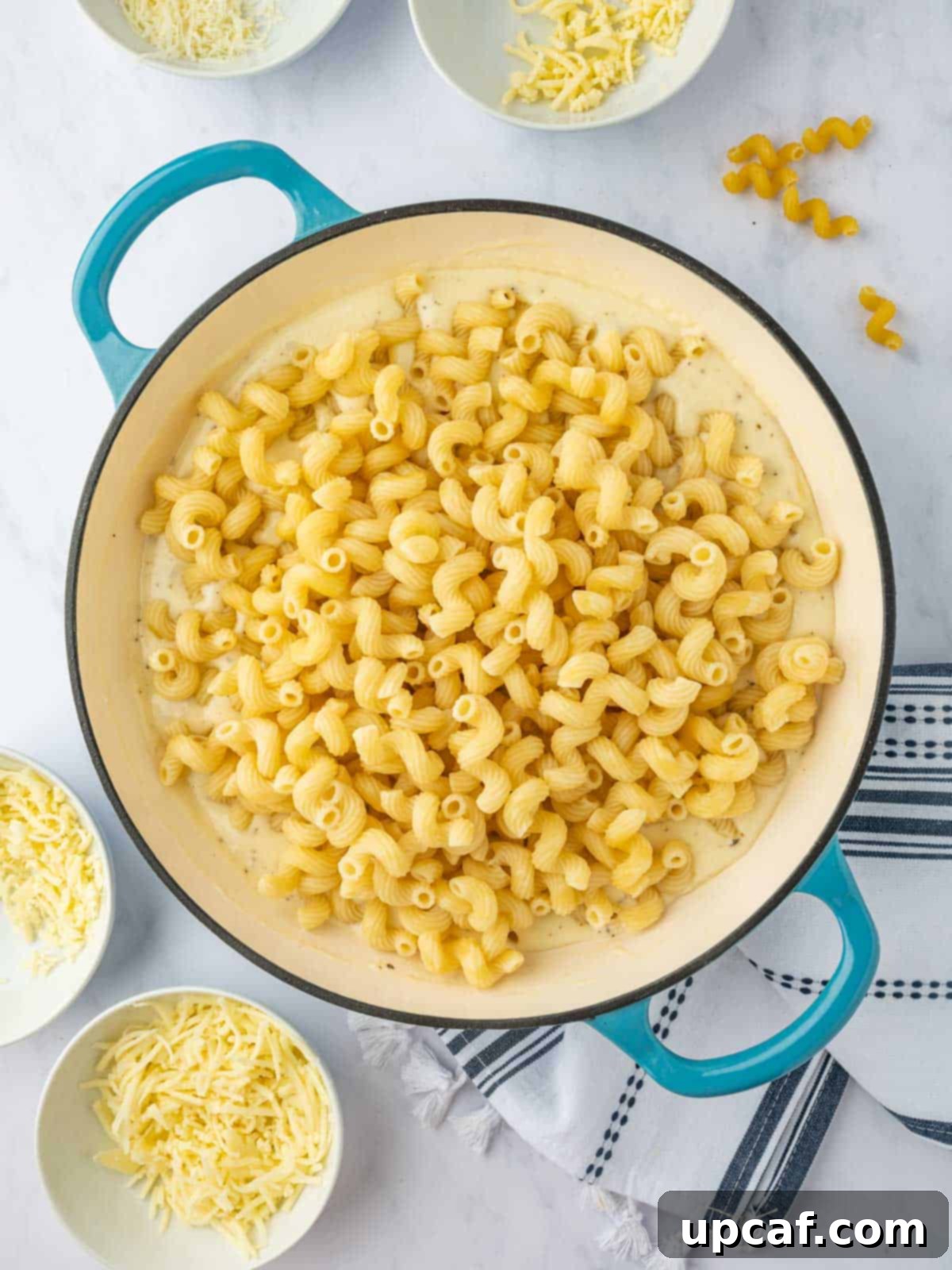 Combine cooked cavatappi pasta with cheese sauce.
