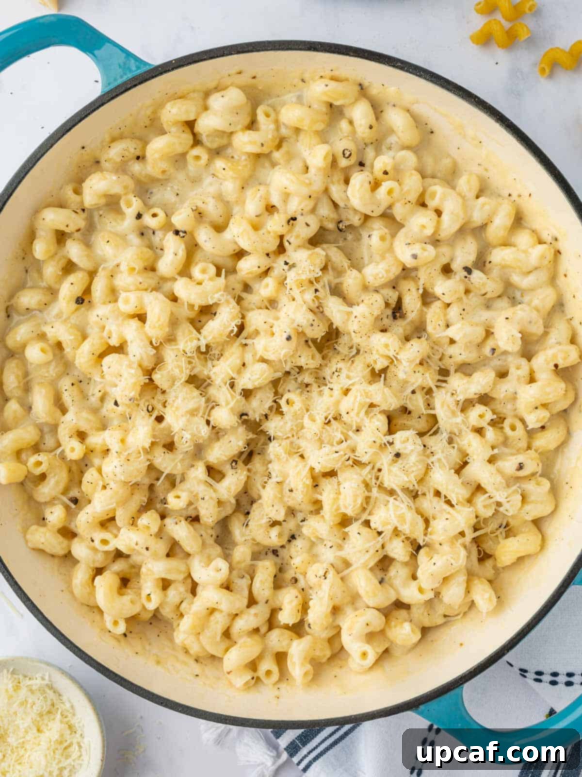 Top four cheese pasta with grated parmesan.