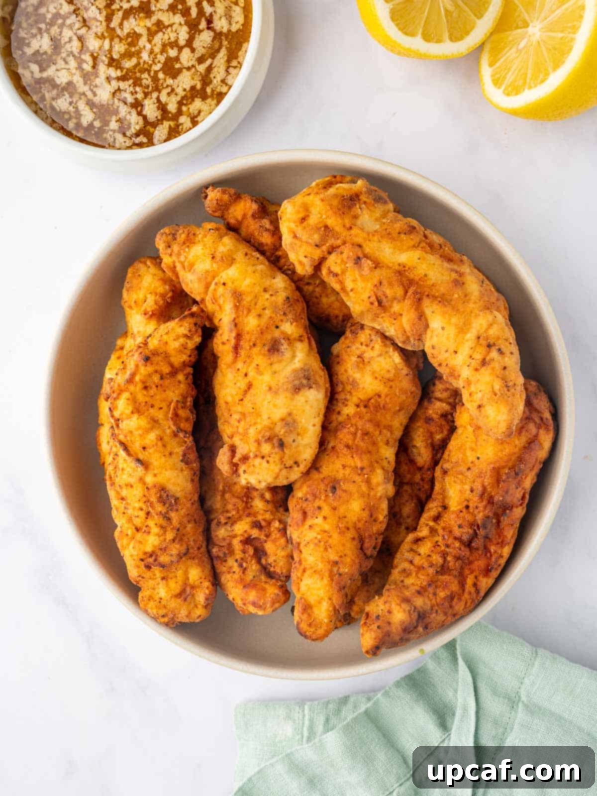 Cooked chicken strips in a bowl.