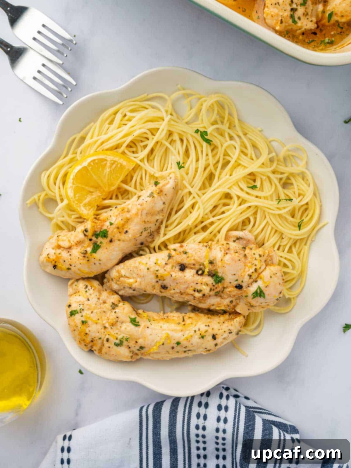 Lemon pepper chicken with pasta on a plate.