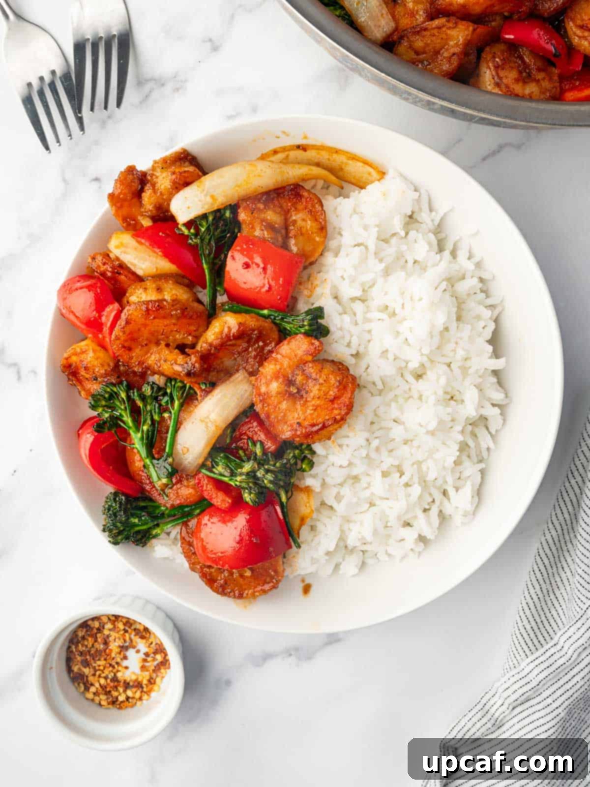 Panda Express Sizzling Shrimp served on a plate with white rice and garnished.
