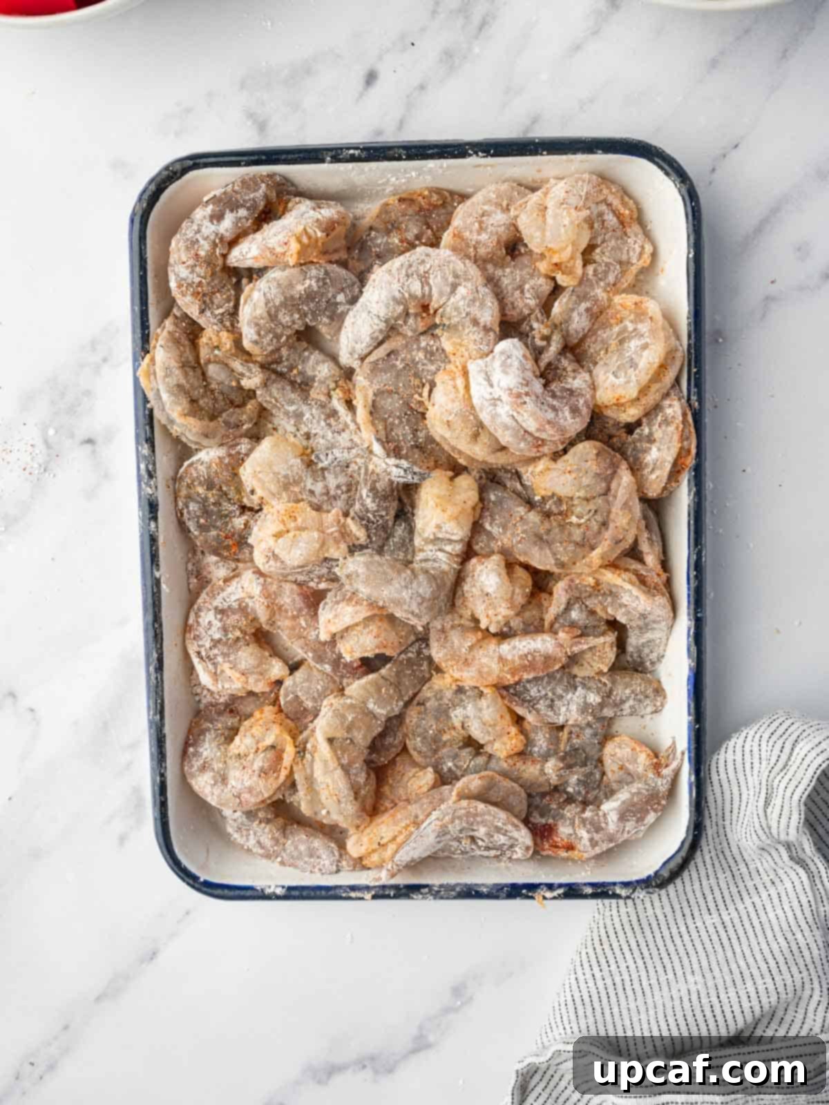 Shrimp evenly coated with cornstarch, ready for frying.