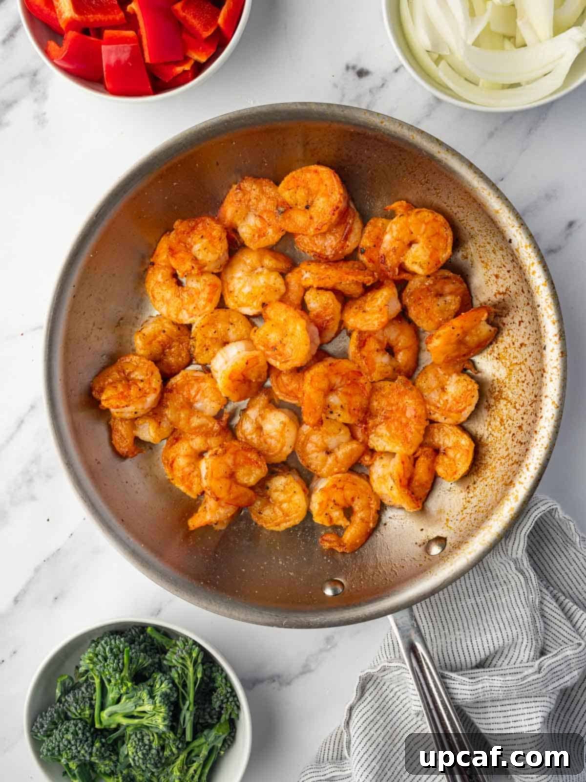 Shrimp sizzling in a hot skillet, turning golden brown.