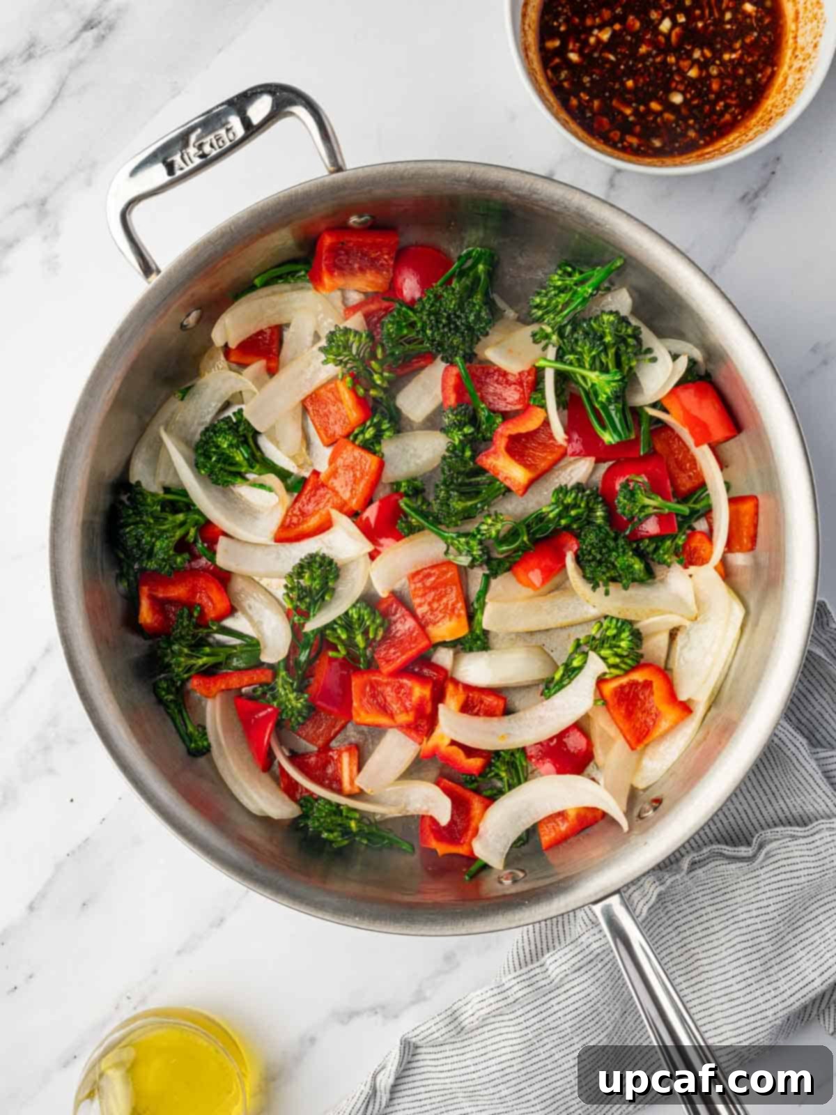 Freshly chopped vegetables stir-frying in a large skillet.