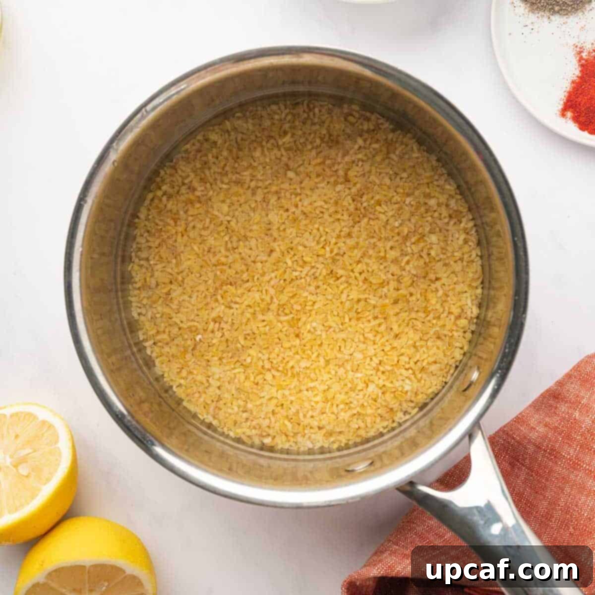 Step 1: Rinsed bulgur wheat in a pot before boiling, next to a measuring cup of water.