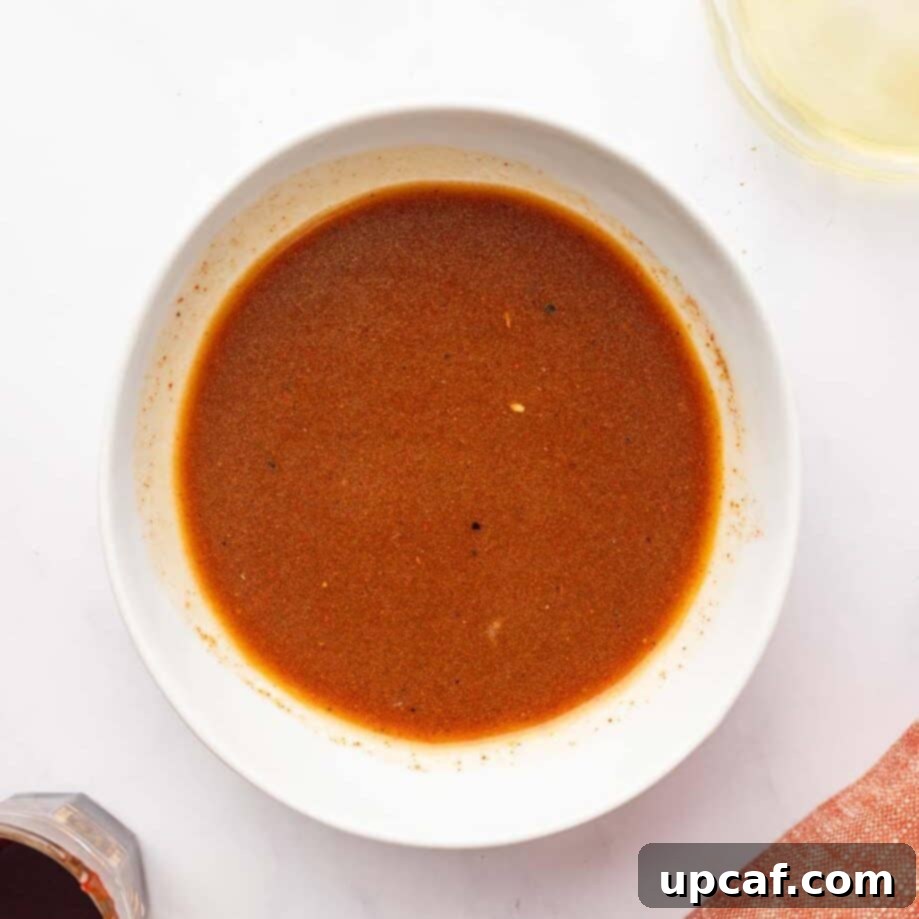 Kisir salad dressing ingredients, including olive oil, lemon juice, pomegranate molasses, and spices, whisked together in a small bowl.