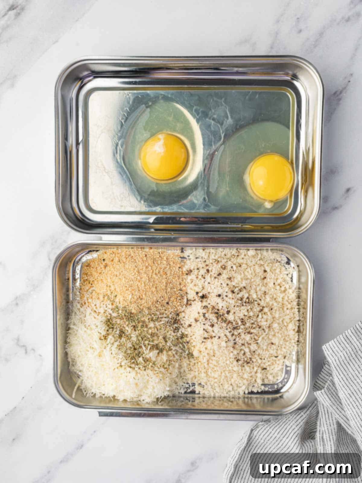 Egg wash and breading stations for making fried ravioli coating.