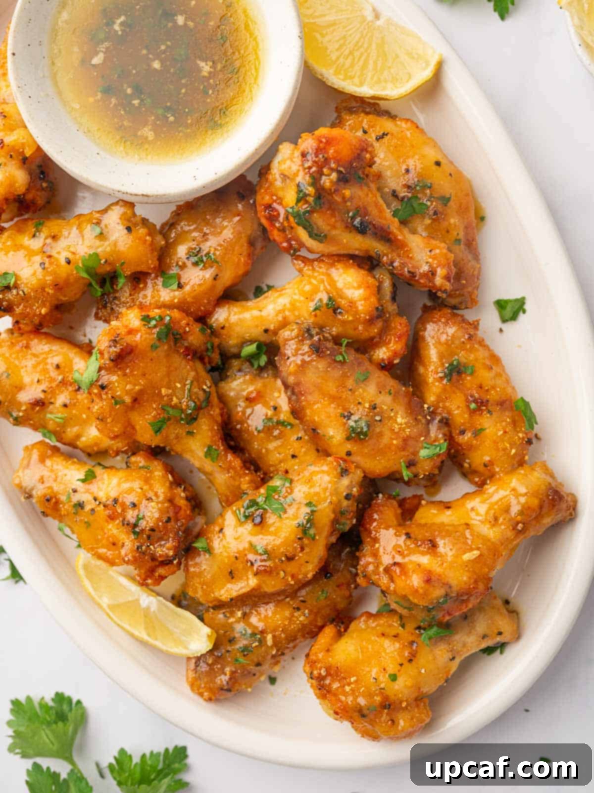 Honey-Glazed Lemon Pepper Wings 9 A plate of honey lemon pepper wings garnished with parsley.