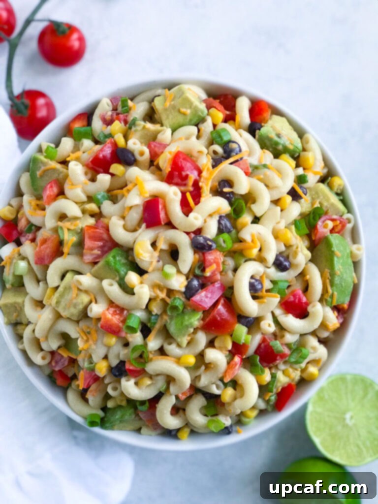 Large white bowl filled with colorful Taco Ranch Pasta Salad, featuring pasta, corn, beans, tomatoes, and a creamy dressing.