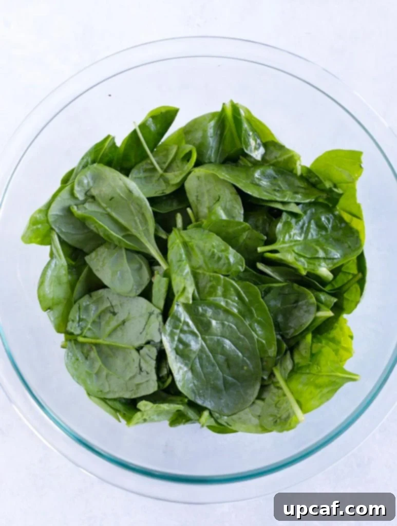 Sweet & Tangy Strawberry Spinach Feta Salad 2 Coating spinach with dressing for Strawberry Spinach Salad