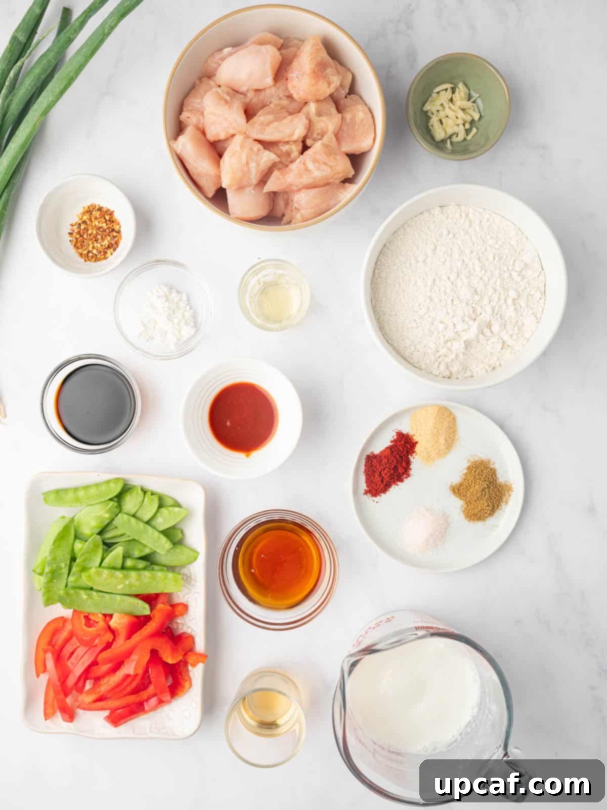 Various fresh ingredients for crispy honey chili chicken laid out on a table.