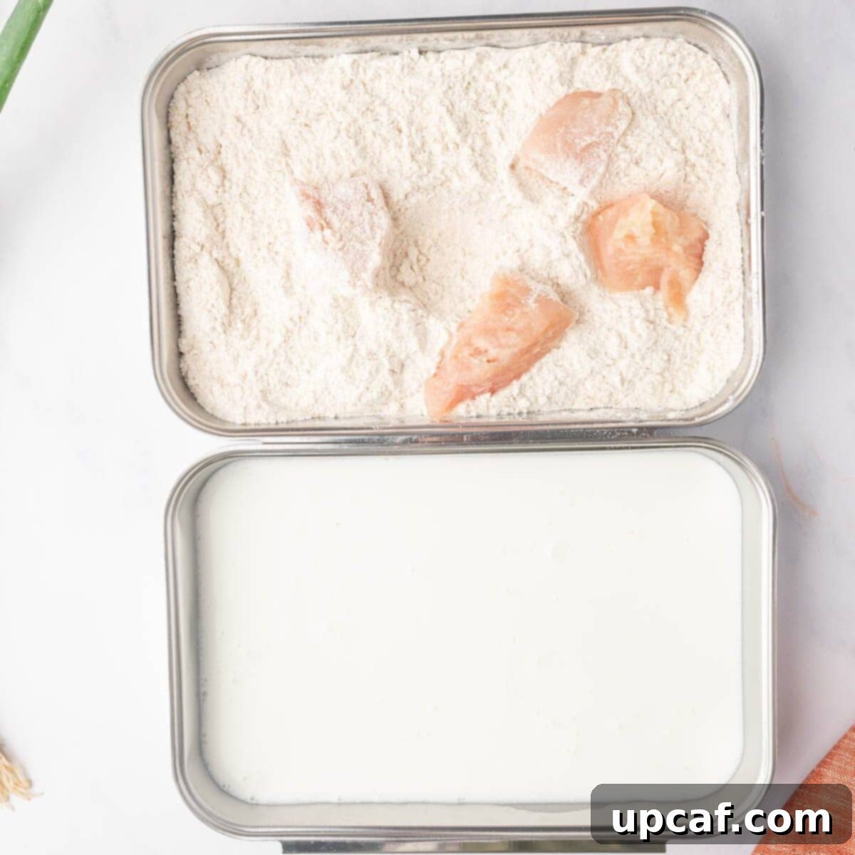 Process of dredging raw chicken pieces in buttermilk and seasoned flour mixtures in separate bowls.