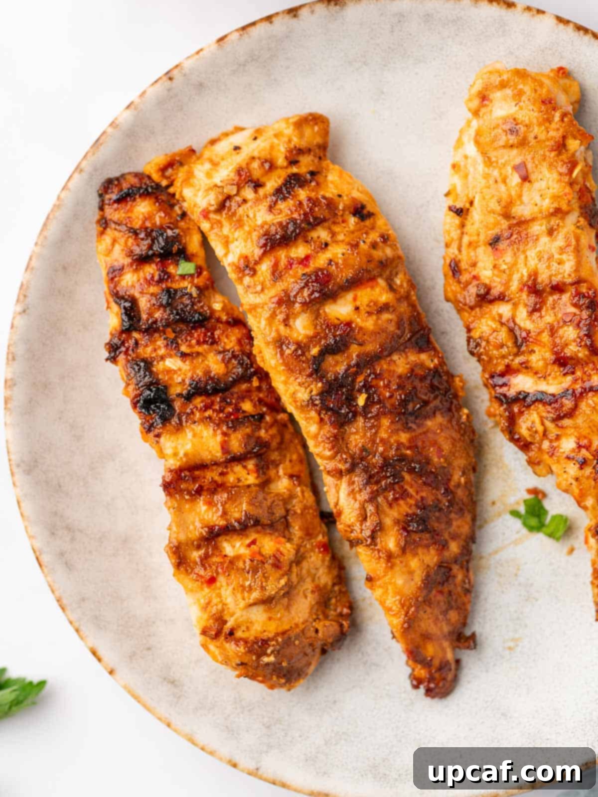 Fiery Peri Peri Chicken 8 Three perfectly grilled peri peri chicken tenders arranged on a simple white plate.