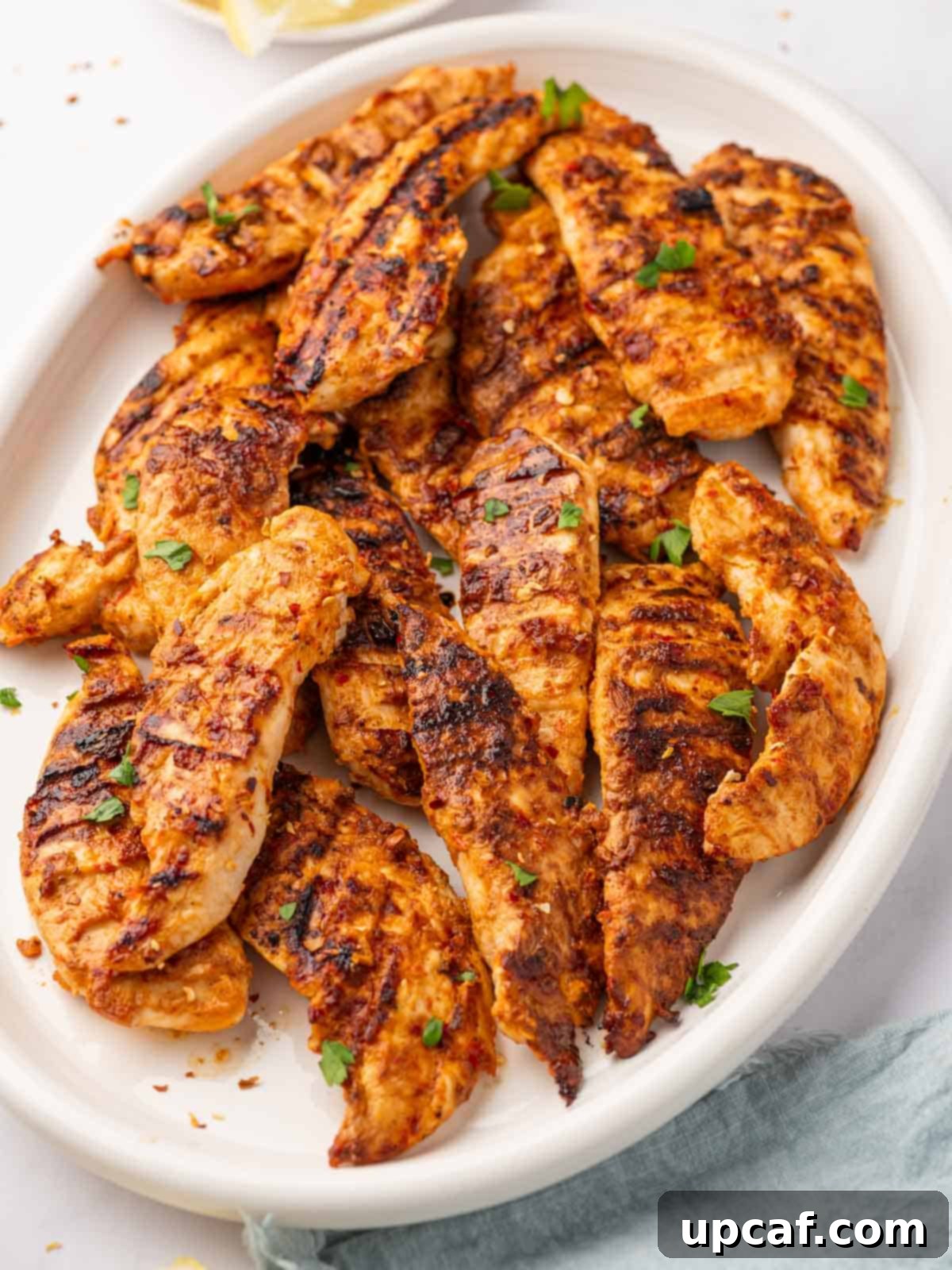 Fiery Peri Peri Chicken 10 A close-up of a pile of spicy peri peri chicken tenders, perfectly grilled and ready to eat.
