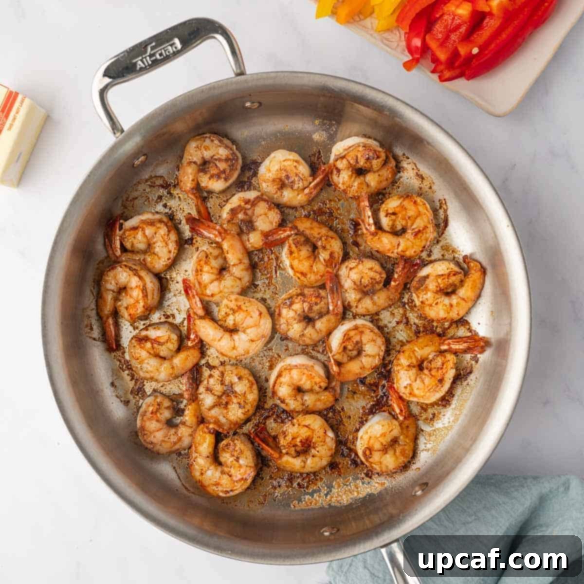 One Love Shrimp Pasta 5 Seasoned shrimp cooking in a hot skillet with melted butter until perfectly pink and opaque.