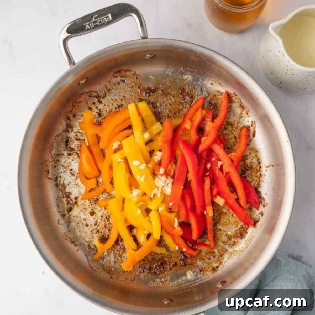 One Love Shrimp Pasta 6 Colorful tri-color bell peppers added to a skillet with sautéed garlic and butter, cooking until softened.