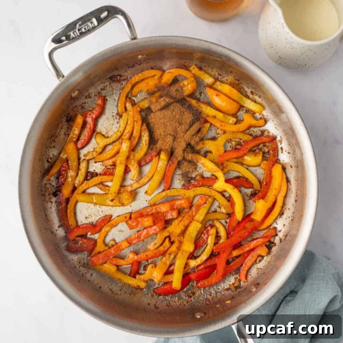 One Love Shrimp Pasta 7 The remaining jerk seasoning and turmeric powder being stirred into the softened bell peppers in the skillet.