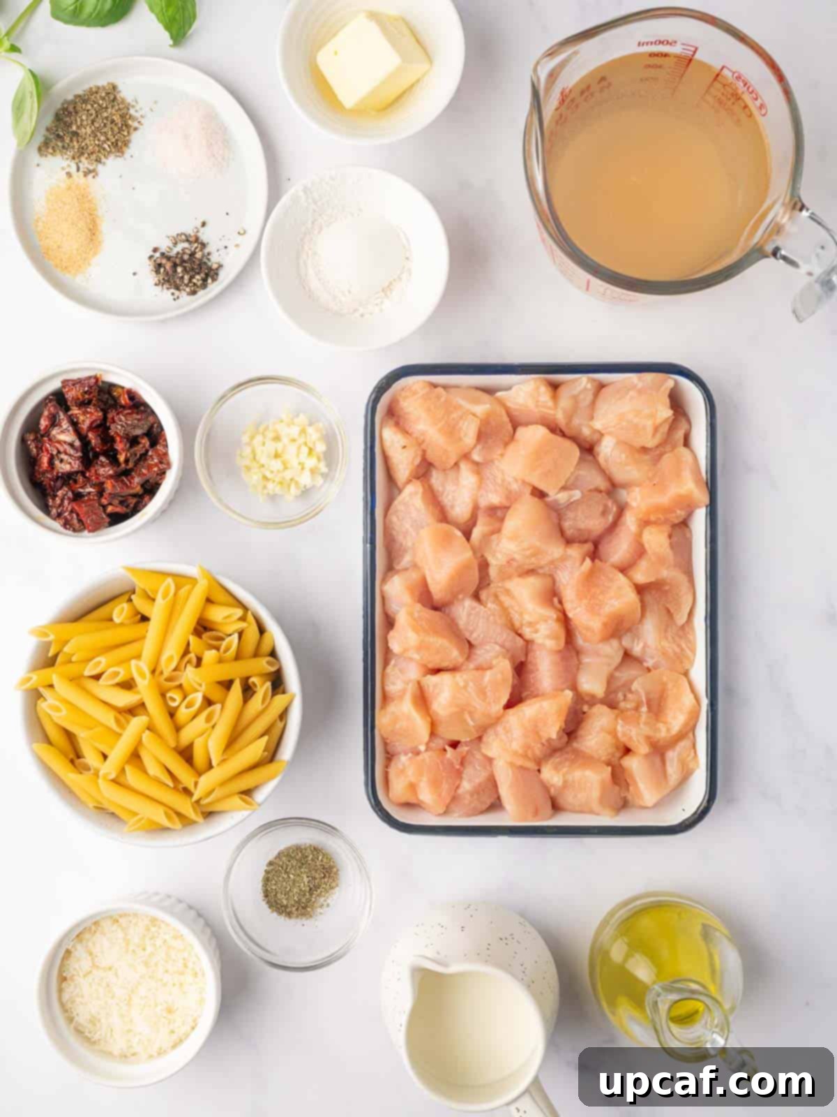 A selection of fresh ingredients laid out, including chicken, pasta, sun-dried tomatoes, and herbs, essential for Marry Me Chicken Pasta.