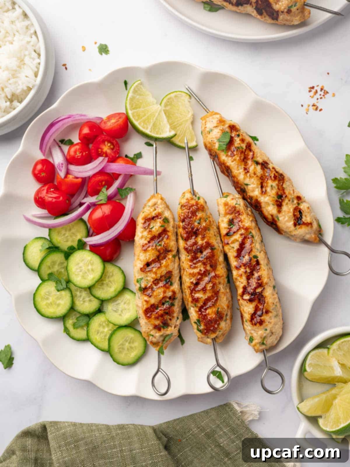 Perfectly Spiced Chicken Kofta 2 A vibrant platter of perfectly grilled chicken kofta skewers alongside fresh, colorful vegetables.