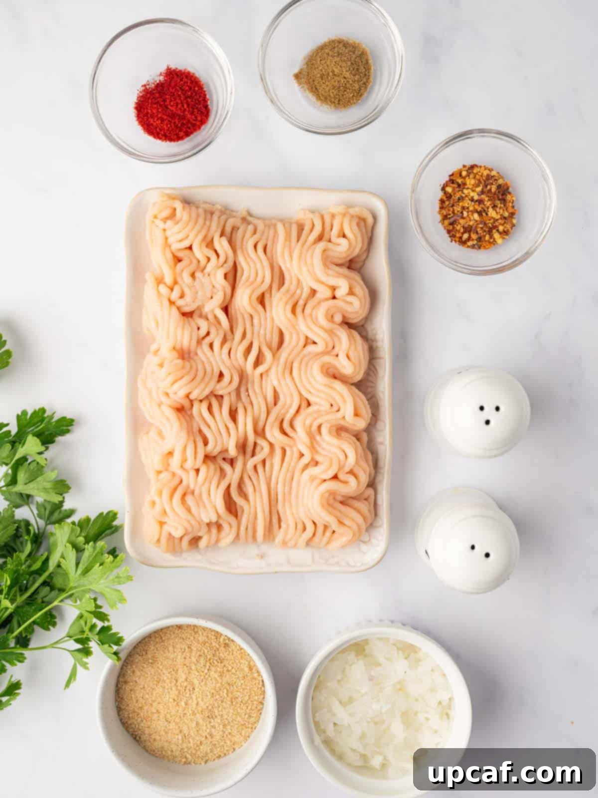 Perfectly Spiced Chicken Kofta 3 All the fresh ingredients laid out for making chicken kofta, including ground chicken, grated onion, breadcrumbs, fresh parsley, and various spices.