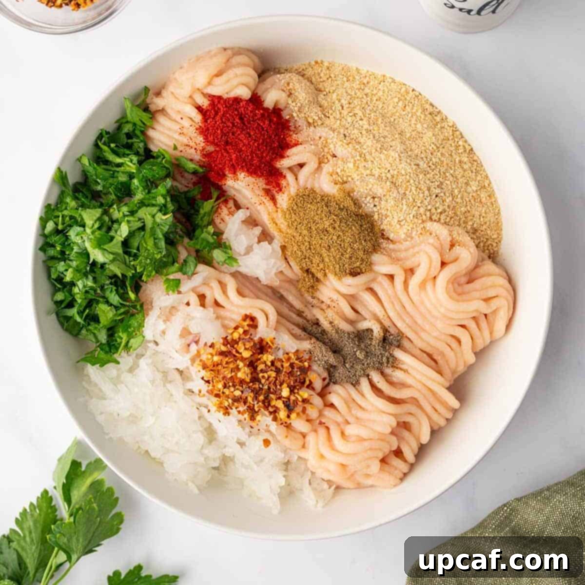 Perfectly Spiced Chicken Kofta 4 Ground chicken is mixed with herbs and seasonings in a large bowl, showing the initial preparation stage.