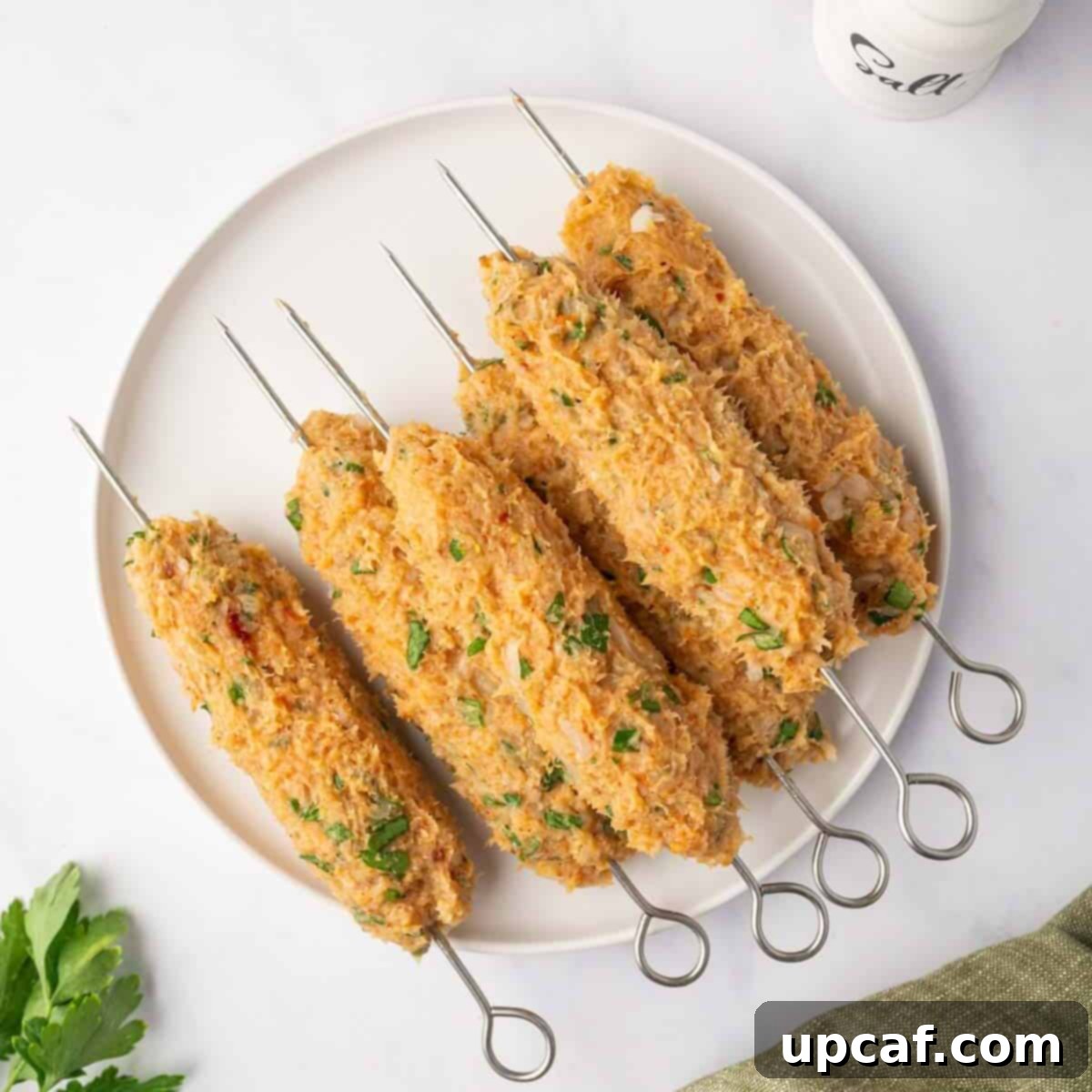 Perfectly Spiced Chicken Kofta 6 The chicken mixture is carefully formed into elongated logs around metal skewers, demonstrating the shaping process.