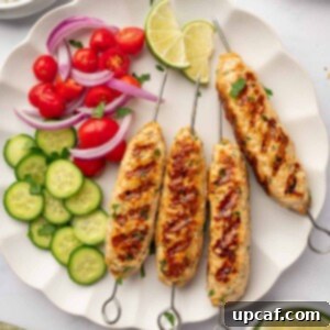 Perfectly Spiced Chicken Kofta 10 Chicken kofta is served on a plate with fresh vegetables and lime wedges.