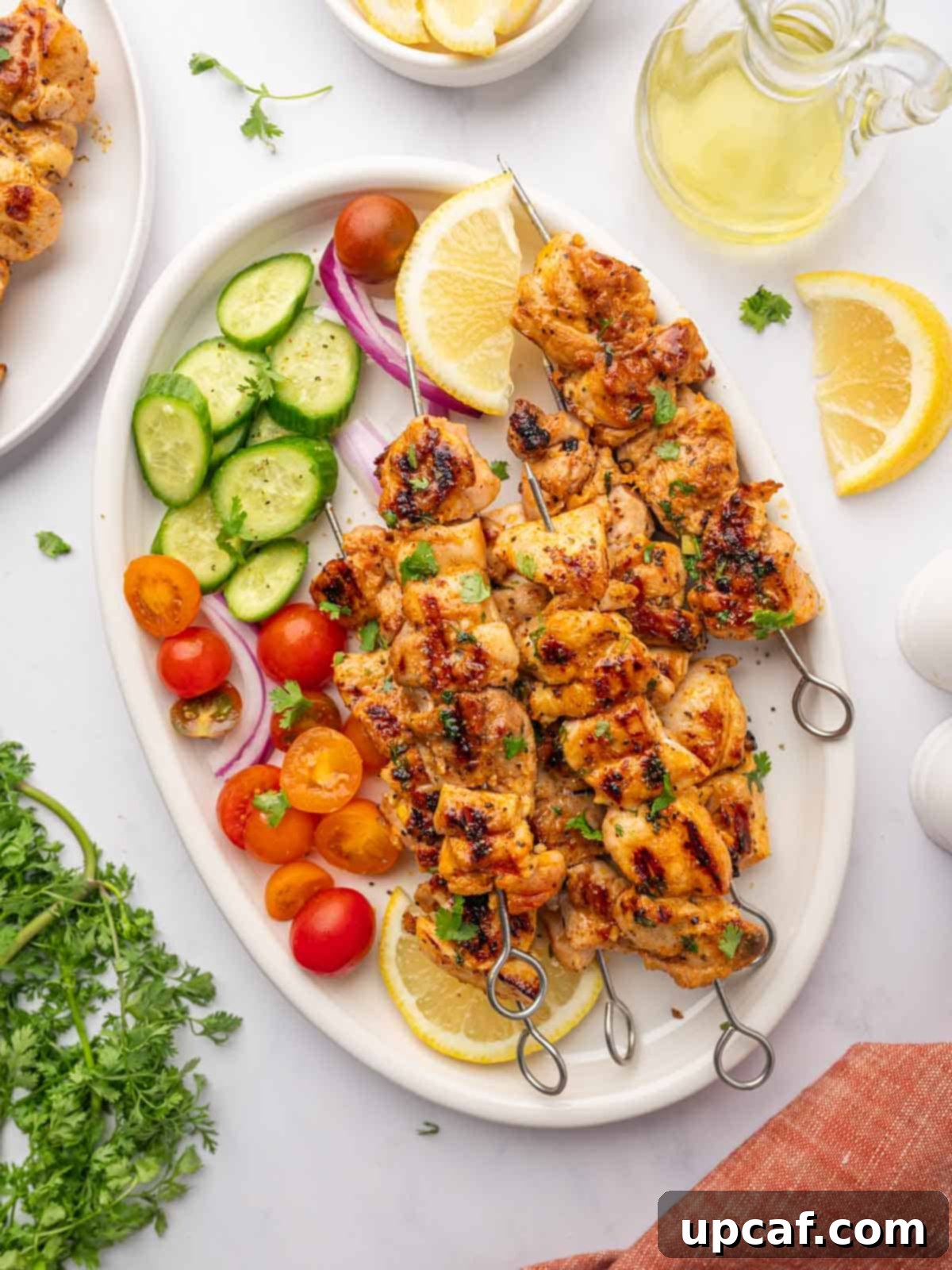 Grilled chicken with vegetables and lemon slices on a platter, showcasing vibrant colors and fresh ingredients.