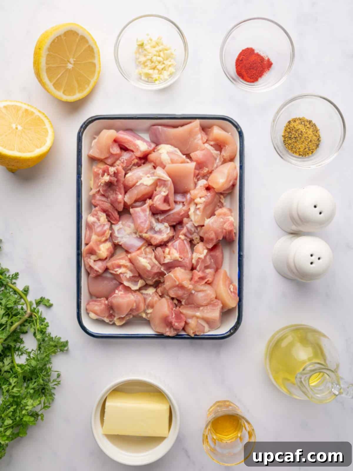 Ingredients needed for grilled lemon pepper chicken skewers, including fresh lemons, chicken pieces, and spices.