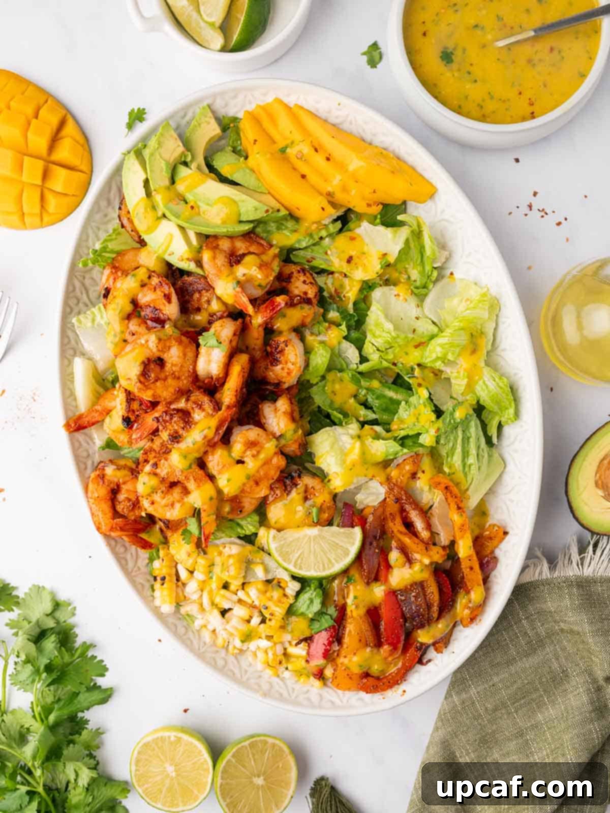 Shrimp salad with mango dressing on a platter, showcasing vibrant colors and fresh ingredients.