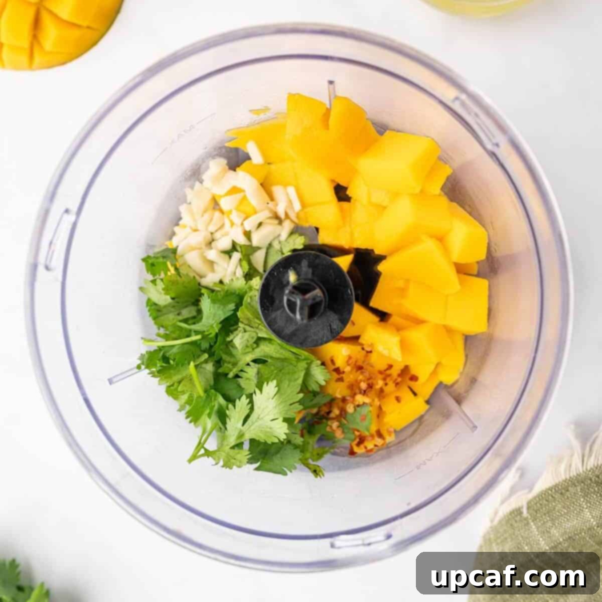 Preparing the mango salad dressing in a food processor, showing the creamy texture and vibrant color.