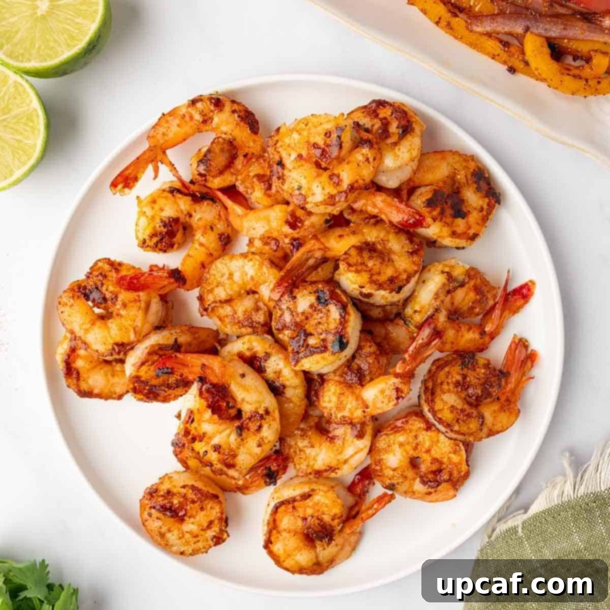 Grilled shrimp with perfect char marks arranged on a plate.