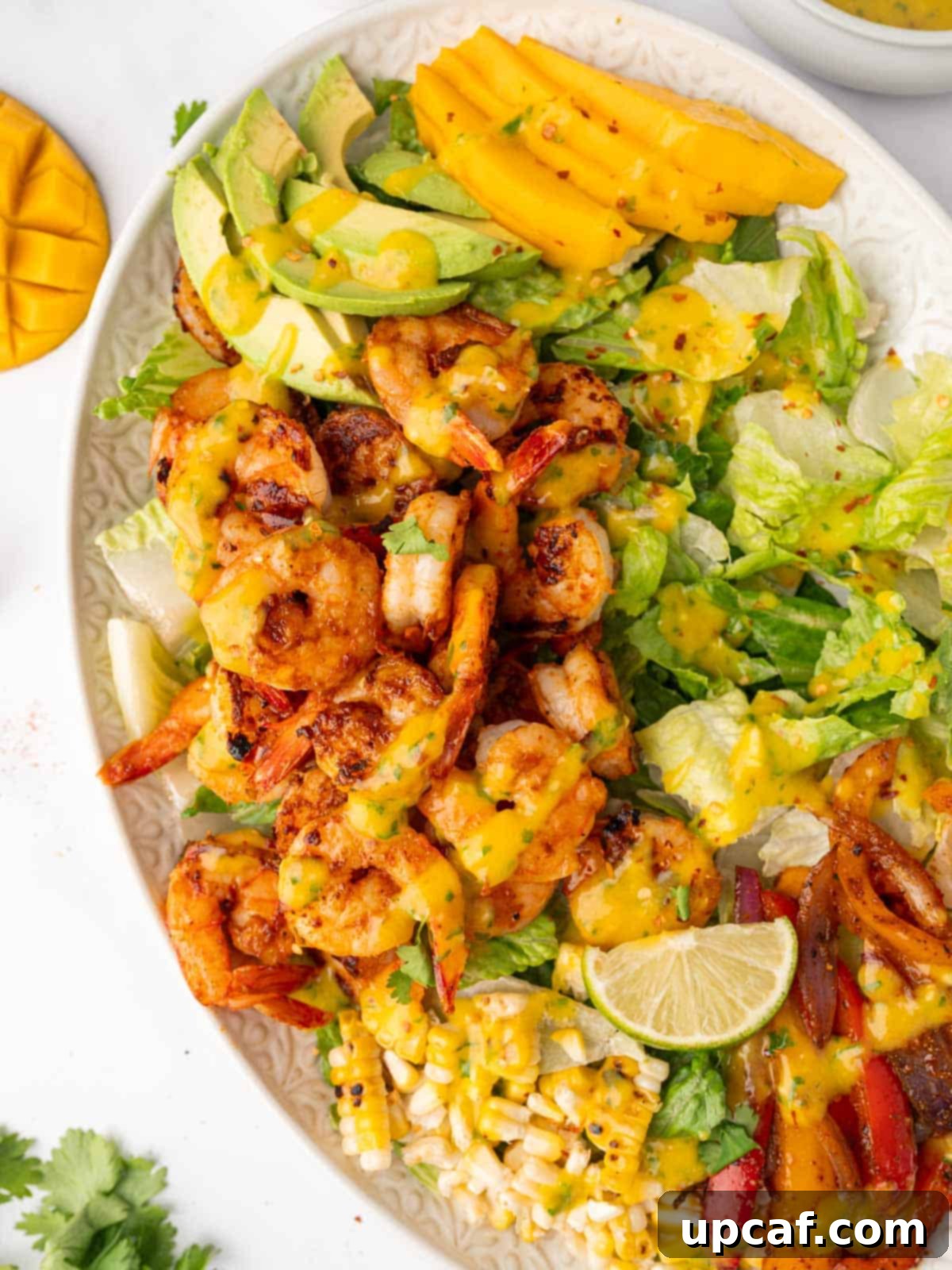 Shrimp salad with mango, avocado, and grilled vegetables arranged on a platter, beautifully presented and ready to be served.