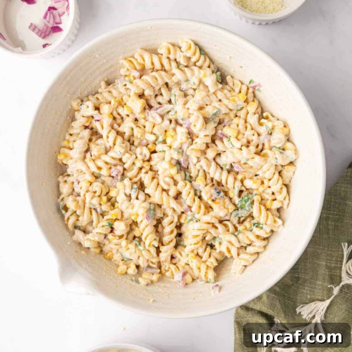 A bowl of spiral pasta with corn and cilantro lime dressing.