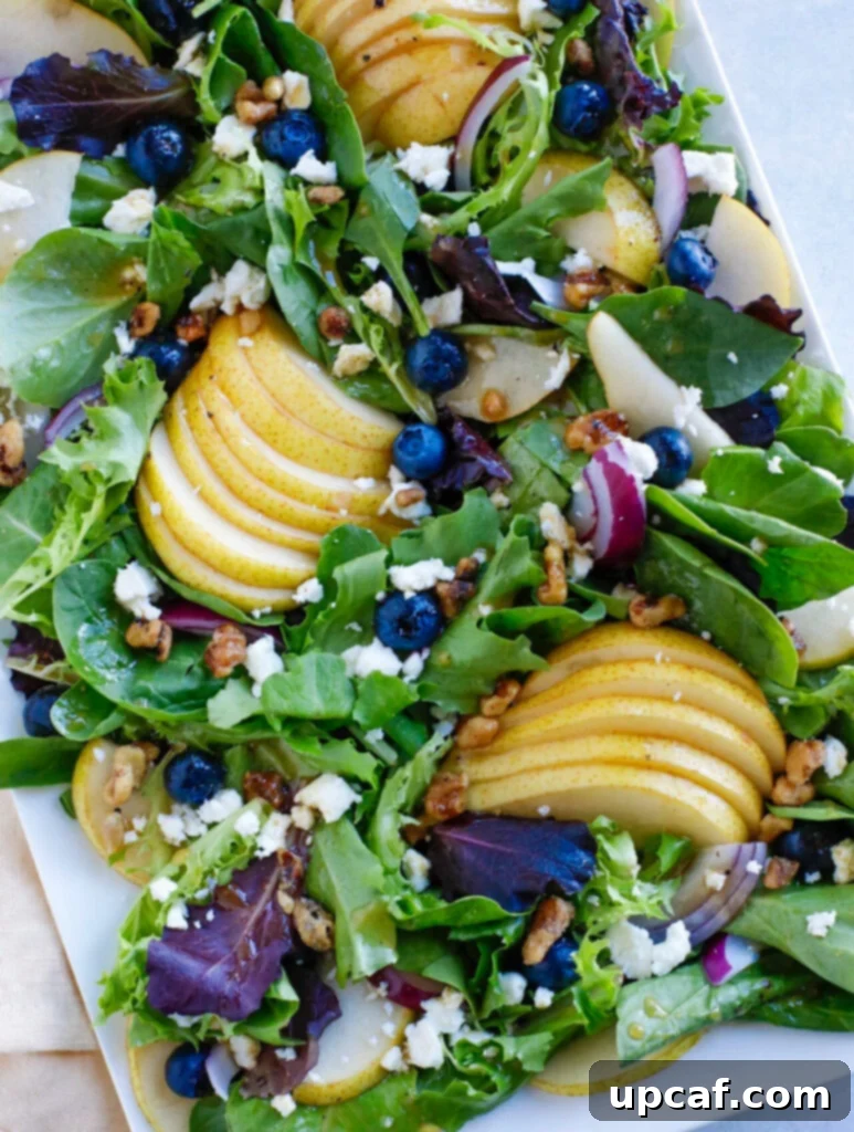 fall salad on a white plate. A vibrant Autumn Pear Salad, ready to be enjoyed.