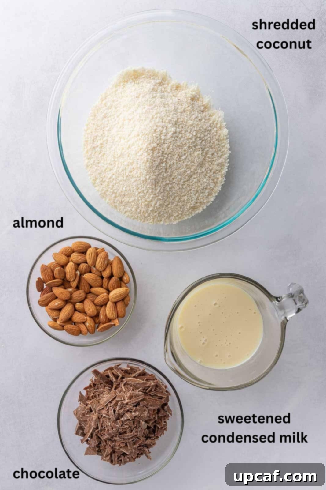 Island Coconut Chocolate Dream 3 Ingredients laid out for making coconut chocolate bars, including coconut, condensed milk, chocolate chips, and almonds.