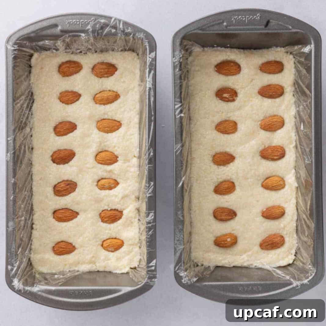 Island Coconut Chocolate Dream 5 The coconut and almond candy bar filling is pressed evenly into two pans lined with plastic wrap, ready for chilling.