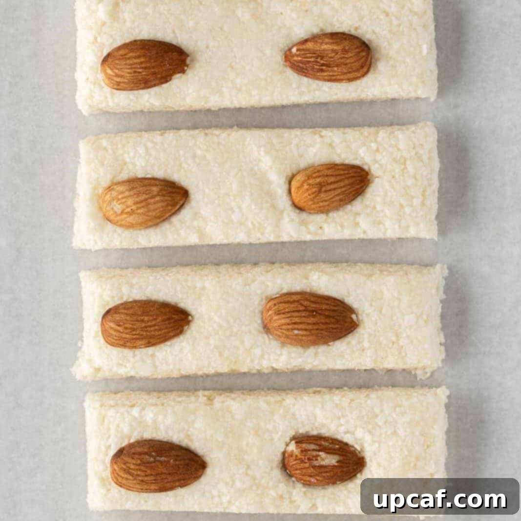 Island Coconut Chocolate Dream 6 The chilled and firm candy bar filling is carefully cut into individual bars with almonds on top.