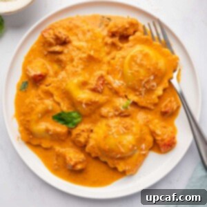 Decadent Lobster Ravioli Sauce 13 A fork rests on a plate of lobster ravioli.